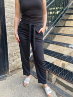 Step into effortless style with the Alice Black Crepe High Waist Pants. Designed for both comfort and chicness, these pants feature a flattering straight leg and a stylish self-tie belt, perfect for showcasing your fashion sense. 

- High waist with a self-tie belt for a customised fit 
- Textured knit crepe for added style 
- Convenient pockets for practicality 
- Relaxed straight fit for all-day comfort 
- Elastic back waistband for ease of movement 
