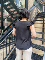 Elevate your wardrobe with the Bodhi Black Flutter Sleeve Blouse. This chic piece features a split neck and delicate ruffle sleeves, making it a perfect addition for any occasion. Effortlessly versatile, you can dress it up for a night out or keep it casual for brunch with friends. 

- Split neck design for a modern twist 
- Flutter sleeves with ruffle detail for added elegance 
- Versatile style—dress it up or down with ease 
- Ideal for both casual and dressy events 