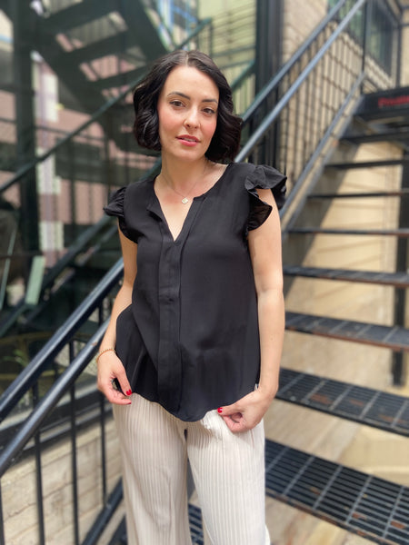 Elevate your wardrobe with the Bodhi Black Flutter Sleeve Blouse. This chic piece features a split neck and delicate ruffle sleeves, making it a perfect addition for any occasion. Effortlessly versatile, you can dress it up for a night out or keep it casual for brunch with friends. 

- Split neck design for a modern twist 
- Flutter sleeves with ruffle detail for added elegance 
- Versatile style—dress it up or down with ease 
- Ideal for both casual and dressy events 