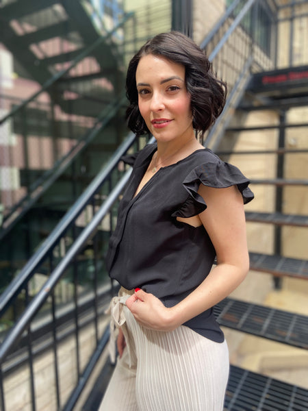 Elevate your wardrobe with the Bodhi Black Flutter Sleeve Blouse. This chic piece features a split neck and delicate ruffle sleeves, making it a perfect addition for any occasion. Effortlessly versatile, you can dress it up for a night out or keep it casual for brunch with friends. 

- Split neck design for a modern twist 
- Flutter sleeves with ruffle detail for added elegance 
- Versatile style—dress it up or down with ease 
- Ideal for both casual and dressy events 
