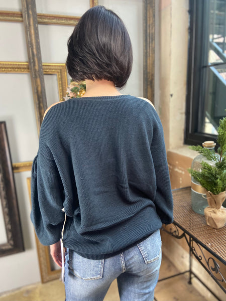 Back side of a dark green cold shoulder sweater