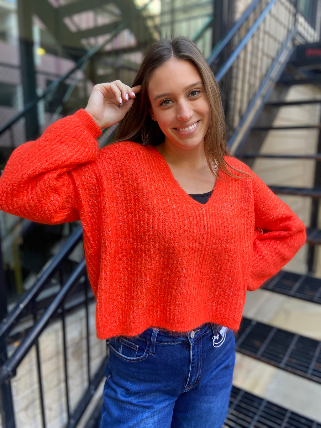 Bright orange long sleeve v neck sweater cropped to waist