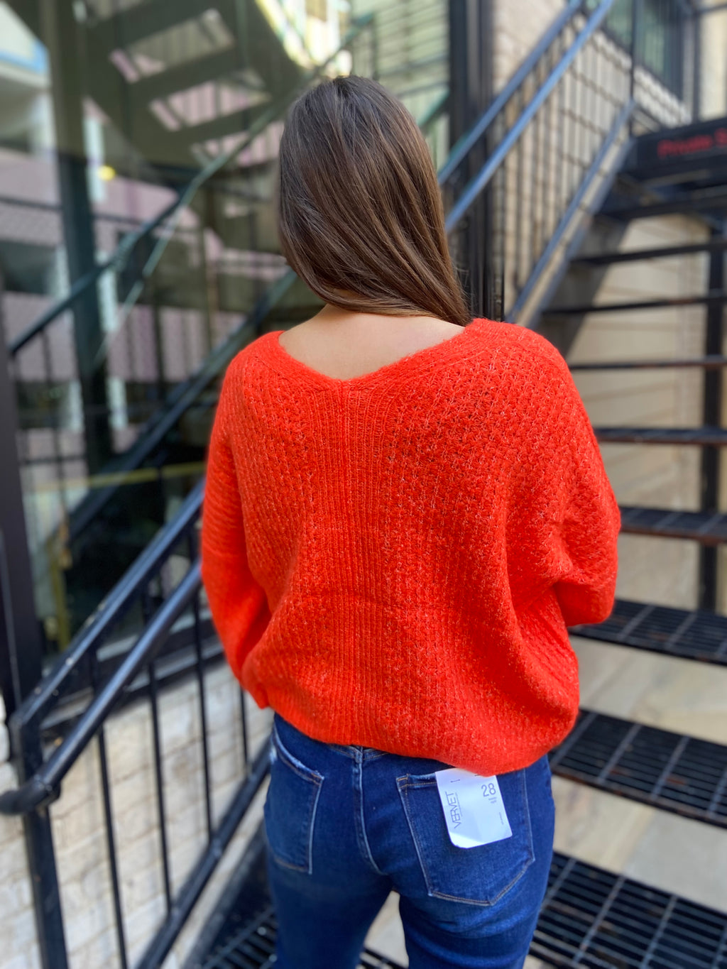 Back view of a bright orange sweater