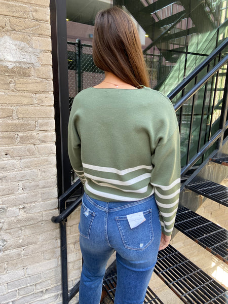 Back view of green & Ivory striped sweater with blue jeans