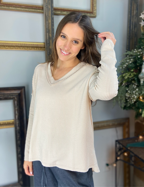 Oatmeal colored hi low long sleeve top with drop shoulders and a v neck