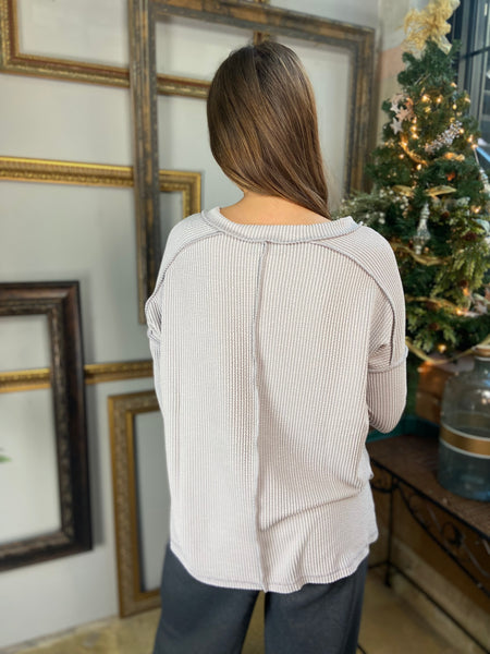 Back view of a silver colored V Neck long sleeved top with drop shoulders