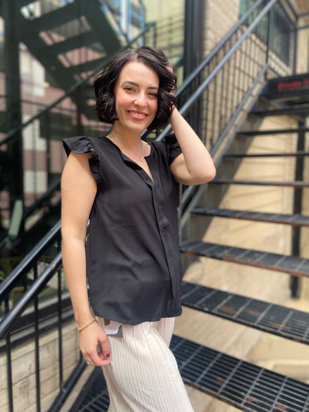 Elevate your wardrobe with the Bodhi Black Flutter Sleeve Blouse. This chic piece features a split neck and delicate ruffle sleeves, making it a perfect addition for any occasion. Effortlessly versatile, you can dress it up for a night out or keep it casual for brunch with friends. 

- Split neck design for a modern twist 
- Flutter sleeves with ruffle detail for added elegance 
- Versatile style—dress it up or down with ease 
- Ideal for both casual and dressy events 