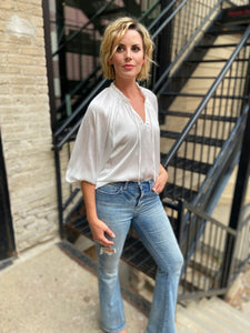 White Satin 3/4 sleeve blouse with v neck and tie paired with blue jeans