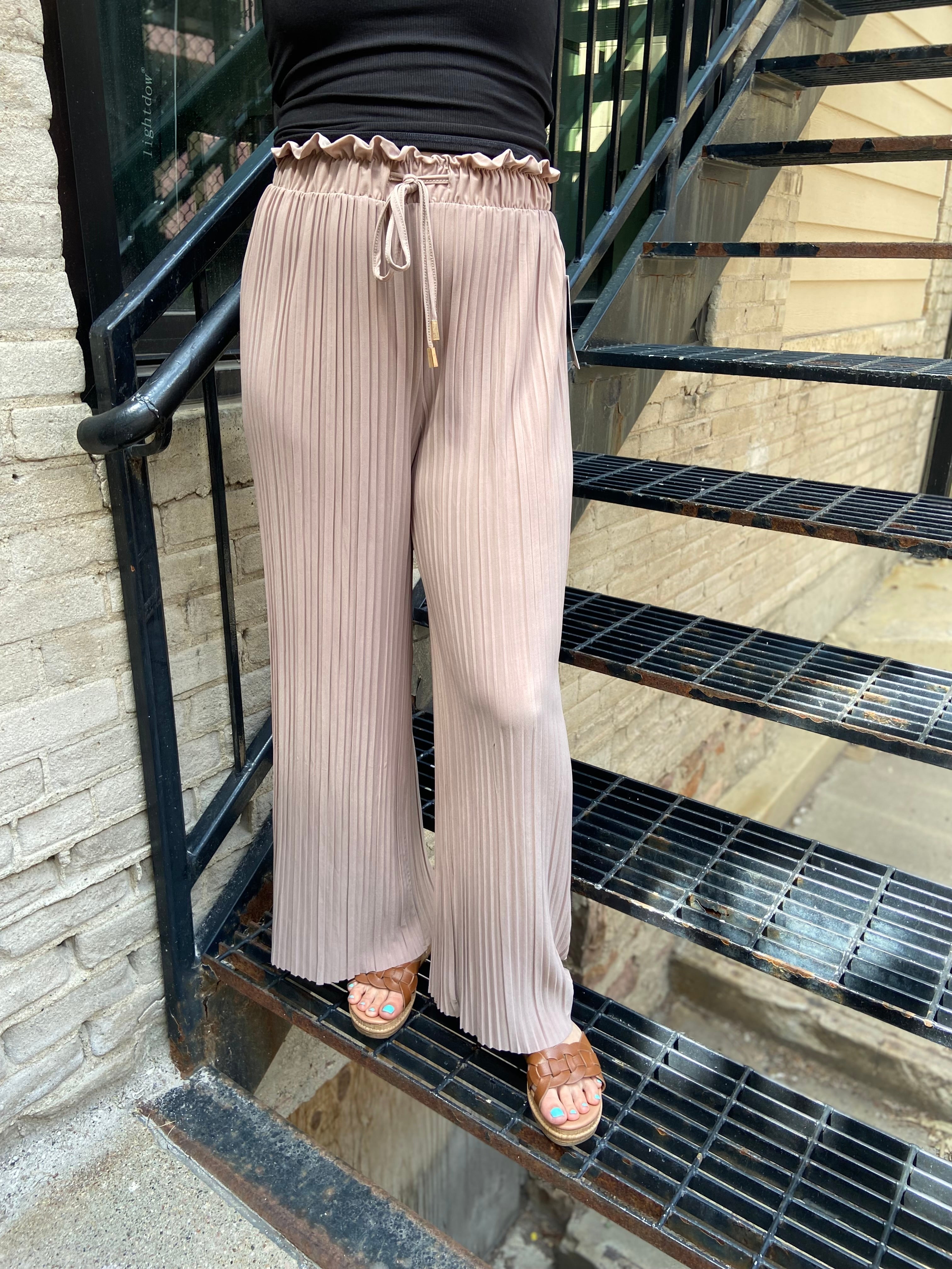 Embrace the whimsical charm of the Charlie Light Coco Pleated Pants! With a playful paper bag waist and a fashionable wide leg design, these pants are perfect for twirling into fall adventures. The adjustable drawstring ensures a comfortable fit, while the delightful stretchy fabric lets you lounge or dance with ease. 

- Playful pleated paper bag waist for a chic look 
- Comfortable stretchy fabric for all-day wear 
- Stylish wide leg silhouette for a flirty flair 
- Easy to care for: machine wash cold, li