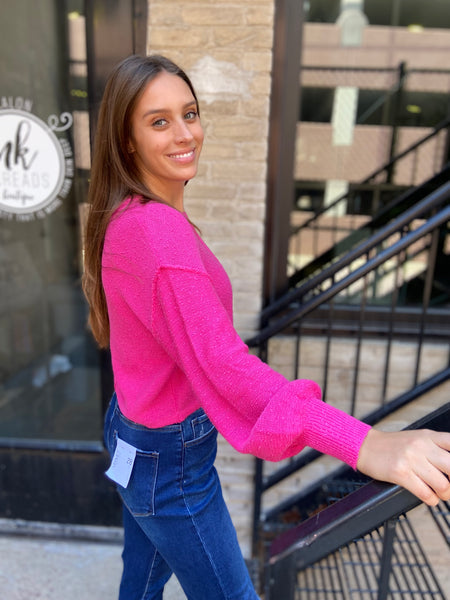 Side view of a fuchsia textured sweater with drop shoulders