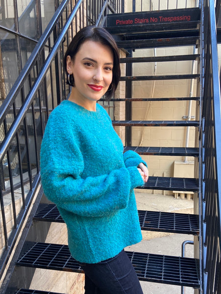 Side view of a turquoise oversized sweater