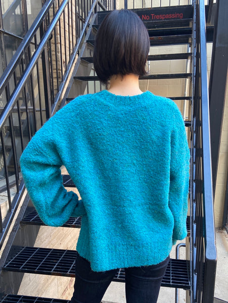 Back view of an oversized turquoise sweater