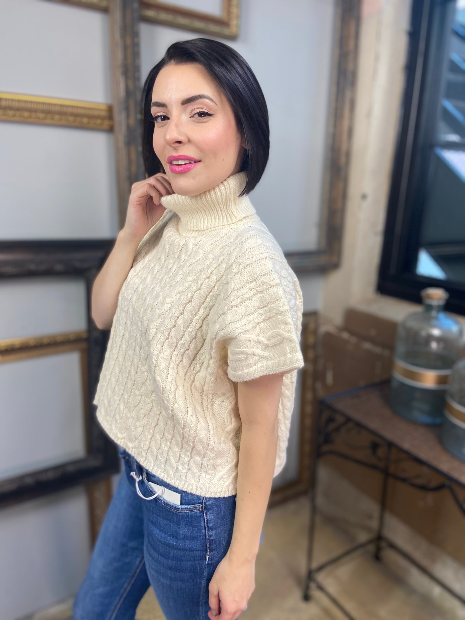 A cream colored short sleeved cable knit sweater with turtle neck from Blu Pepper