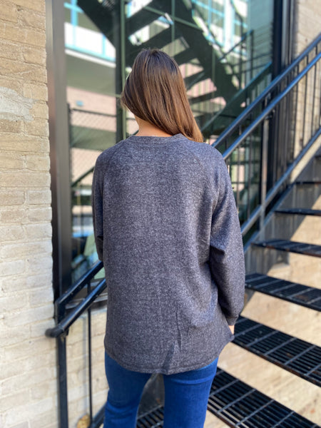 Back view of a brushed knit charcoal colored henley style sweater