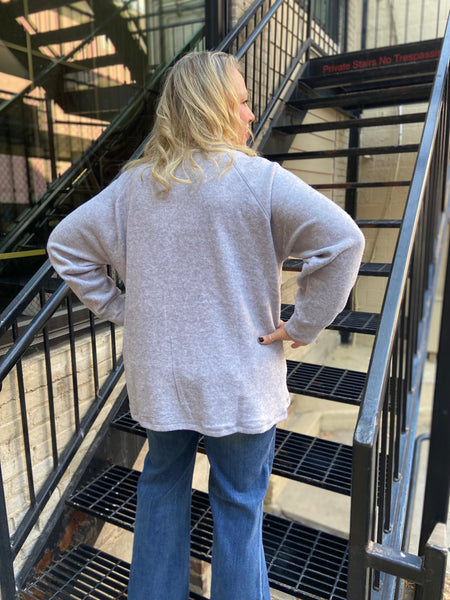 Back view of a  Zenana Brand heather Gray brushed knit oversized henley top paired with blue jeans