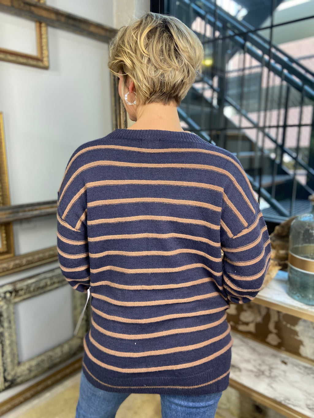 Back view of a navy and mocha striped cardigan paired with blue jeans