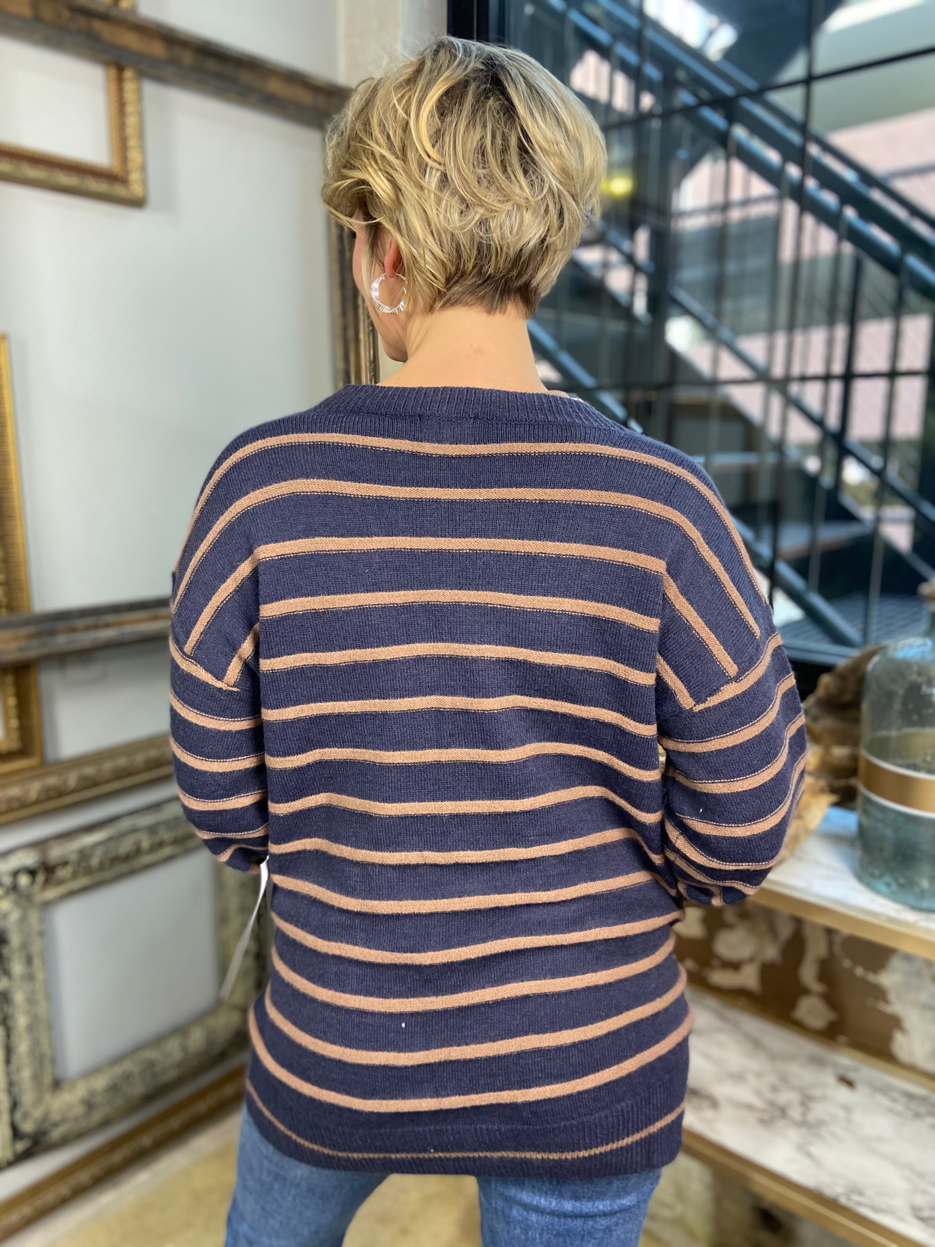 Back view of a navy and mocha striped cardigan paired with blue jeans