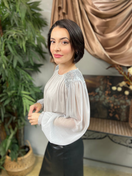 Side view of a silver sequin long sleeve blouse