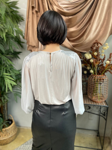 Back view of silver long sleeve blouse with keyhole neck detail