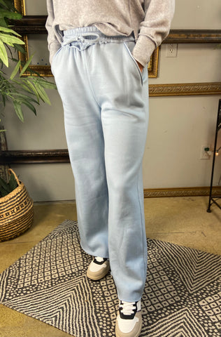 Pair of light blue fleece lined drawstring sweatpants with pockets and wide legs