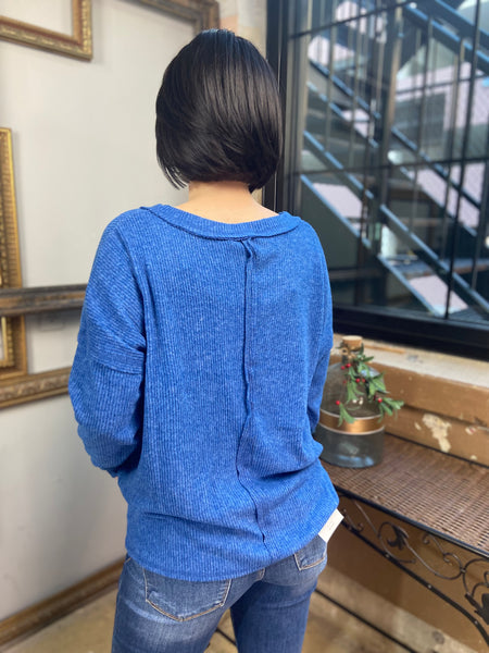 Back view of a  blue colored v neck long sleeve top from Zenana with exposed seams