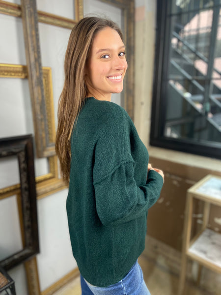 Side view of a deep green colored sweater with drop shoulders from Blu Pepper