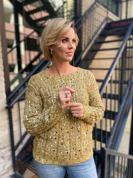 Full front view of a mustard colored textured sweater paired with blue jeans