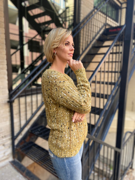 Side view of a mustard colored textured sweater