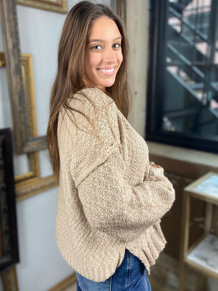 Side view of a taupe colored drop shoulder sweater