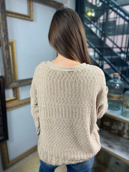 Back view of taupe colored sweater paired with blue jeans