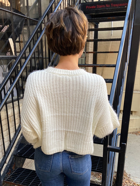 Back view of ivory knit sweater cropped to the waist