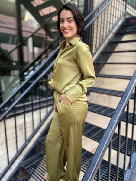 Side view of a matching olive satin button down blouse and pants with pockets