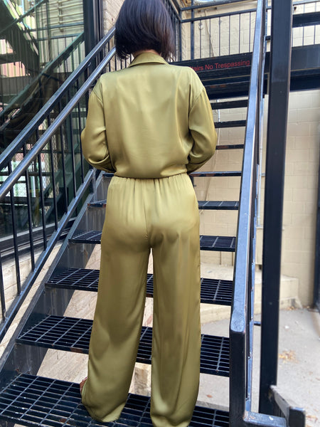 Back view of a pair of olive colored satin wide leg pants with an elastic waist