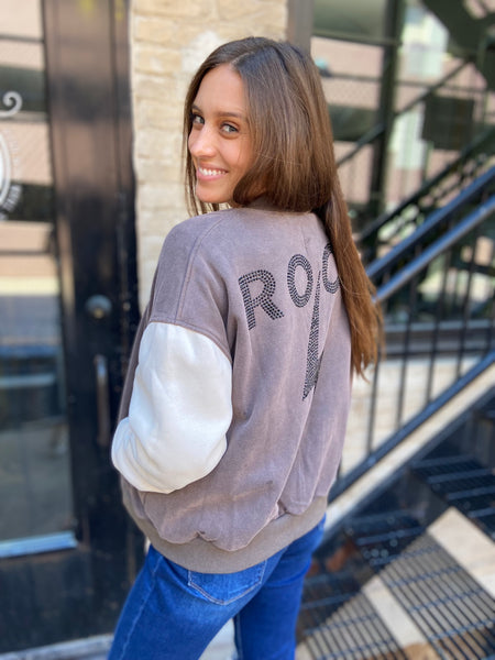 Partial back view of a color block jacket with the word "Rock" spelled in studs.