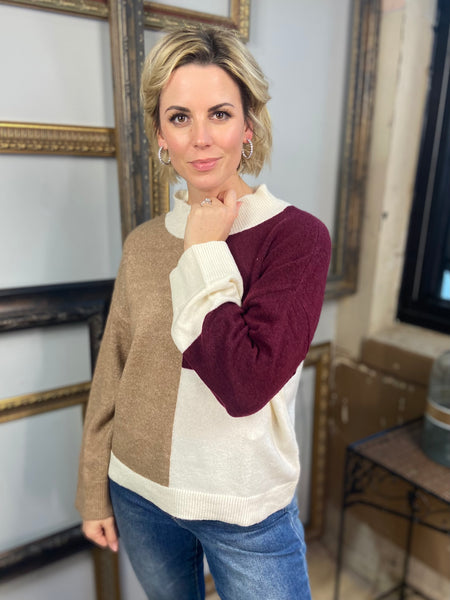 A brown, burgundy and ivory color block sweater from Blu Pepper paired with blue jeans