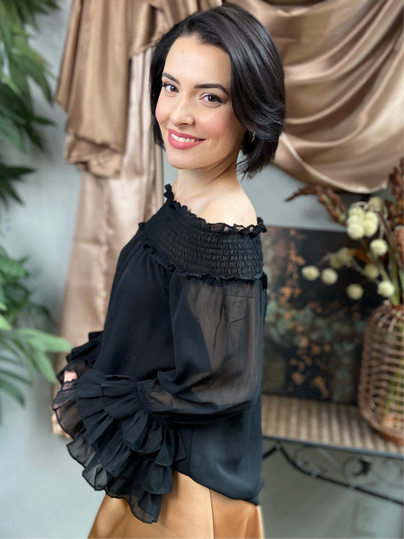 side view of a black off shoulder dressy blouse with ruffles