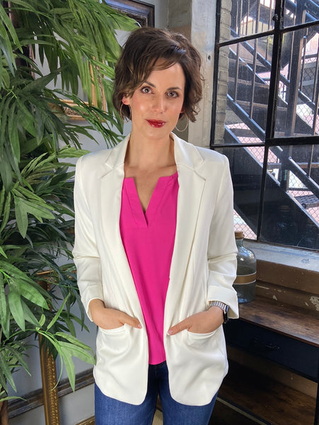 Ivory blazer open over a hot pink blouse