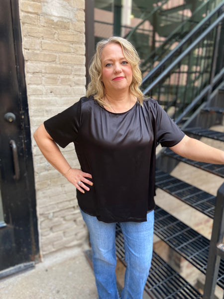 Black satiny half sleeve plus size dressy top paired with blue jeans