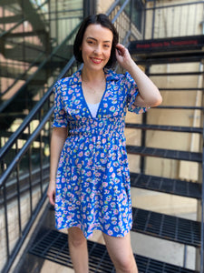 Elevate your style with the Adeline Blue Collard Mini Dress. Featuring a youthful pink and blue floral pattern and delicate lace trim, this detailed dress boasts a flattering mock waist and full lining for a truly show-stopping look. Add a touch of retro design and color pop to your wardrobe today.