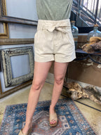 cai cream front bow tie shorts paired with green shirt