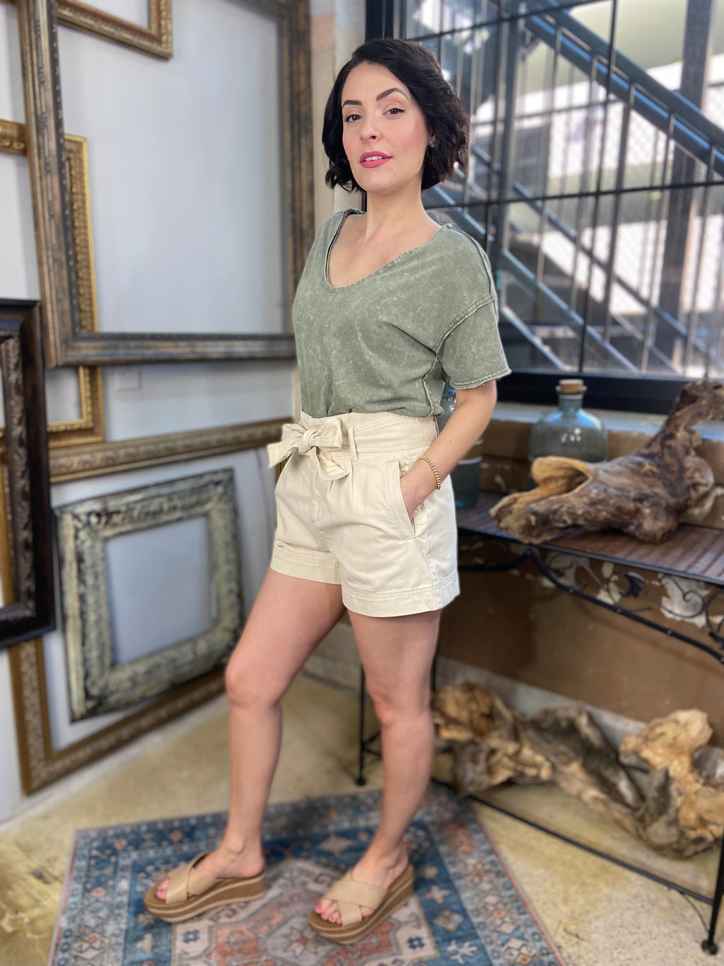 cai cream front bow tie shorts paired with green shirt