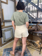 cai cream front bow tie shorts paired with green shirt