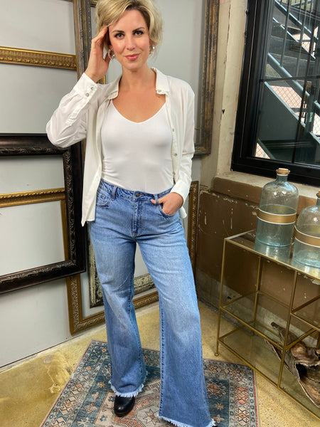 jelly jeans high waisted long raw hem straight wide leg jeans solid medium to light wash denim paired with white button up