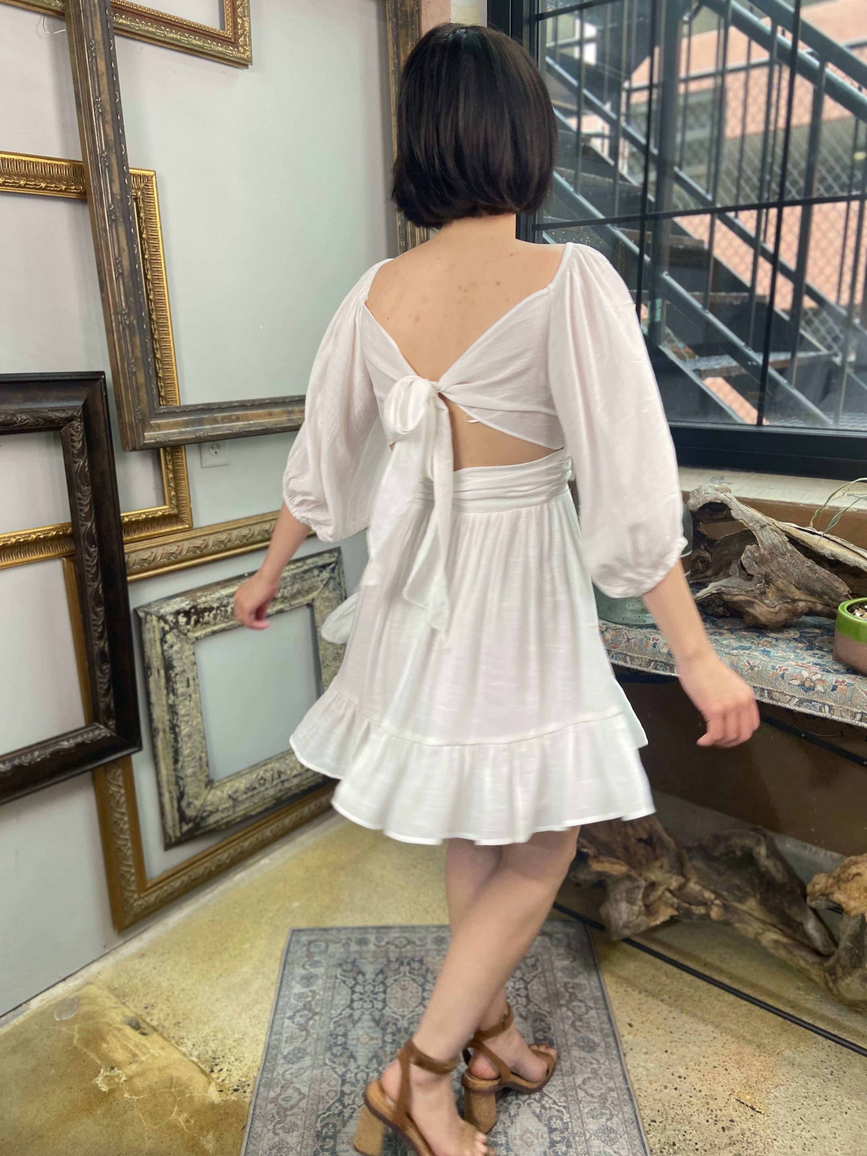 Expertly crafted in a versatile white hue, the Eve White Open Back Mini Dress features a trendy off-shoulder design with a flirty open back and a charming tie closure. Its ruffle-trimmed hem and three-quarter length sleeves create an effortlessly chic look, while the slip lining ensures a comfortable fit. Perfect for any occasion, this dress offers both style and comfort.



Off-shoulder open-back dress

Elegant and stylish design

Made with soft, breathable fabric