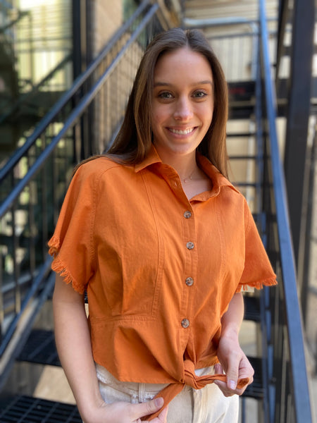 Upgrade your wardrobe with the Juliet Orange Short Sleeve Button Up. This vibrant top features short sleeves with a frayed design and a tie waist for a stylish touch. Made with a cropped cut, this button up delivers a trendy look.