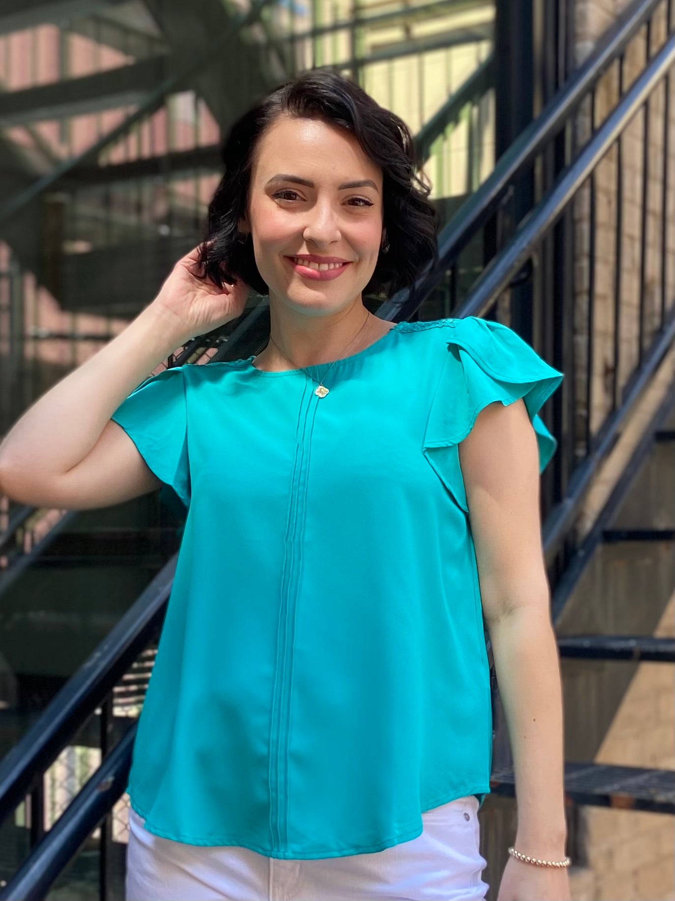Introducing the Kezia Light Teal Ruffle Sleeve Blouse, your new go-to for effortless elegance. This blouse effortlessly combines classic style with a modern twist, featuring:

- Delicate lace trim for a feminine flair
- Flattering tulip sleeves that add grace to any outfit
- Chic pintuck detailing on the front for a refined look
- Keyhole button closure at the back that enhances its charm