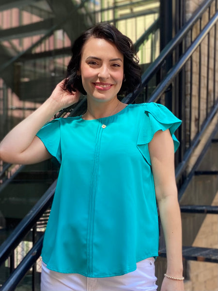 Introducing the Kezia Light Teal Ruffle Sleeve Blouse, your new go-to for effortless elegance. This blouse effortlessly combines classic style with a modern twist, featuring:

- Delicate lace trim for a feminine flair
- Flattering tulip sleeves that add grace to any outfit
- Chic pintuck detailing on the front for a refined look
- Keyhole button closure at the back that enhances its charm