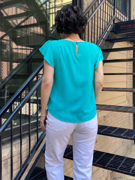 Introducing the Kezia Light Teal Ruffle Sleeve Blouse, your new go-to for effortless elegance. This blouse effortlessly combines classic style with a modern twist, featuring:

- Delicate lace trim for a feminine flair
- Flattering tulip sleeves that add grace to any outfit
- Chic pintuck detailing on the front for a refined look
- Keyhole button closure at the back that enhances its charm