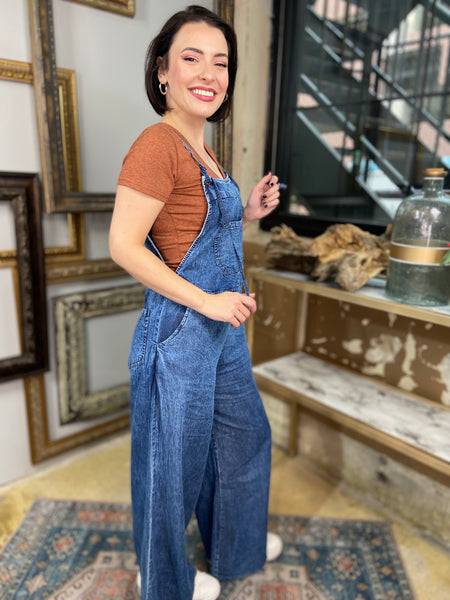 dark wash denim blue overalls jumpsuit wide leg spaghetti straps pockets front and back side view