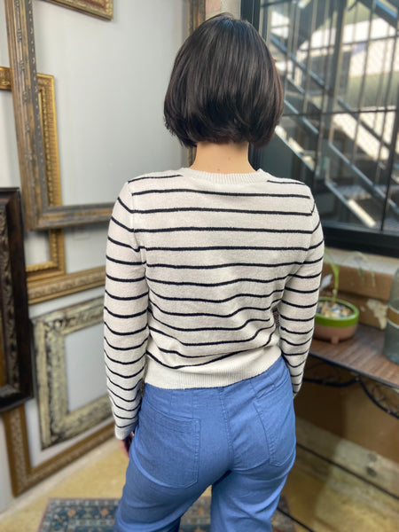 black and white striped button up cardigan paired with blue jeans